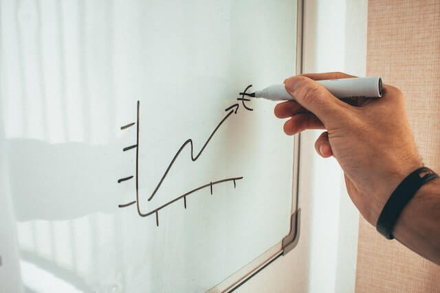 A Financial Advisor drawing a growth chart on whiteboard